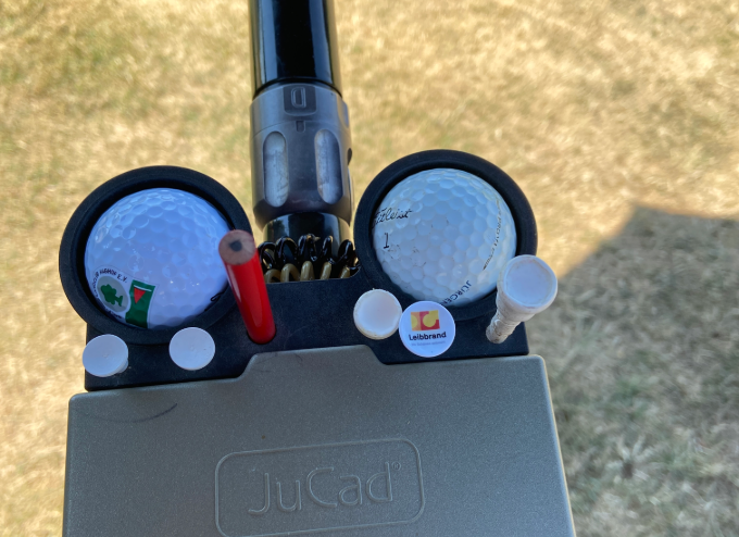 Golf-Tee mit Leibbrand-Logo neben einem Golfball