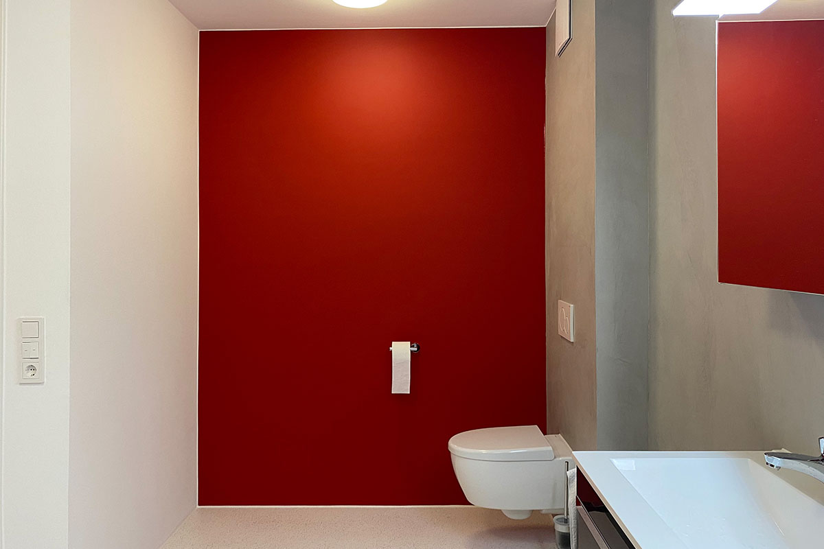 die fugenlose Wandbeschichtung in rot ist ein Highlight im Badezimmer